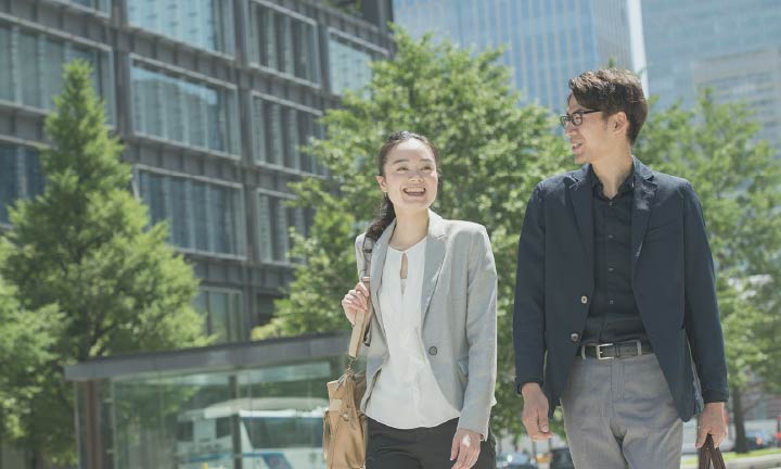 歩きながら笑顔で会話している男女