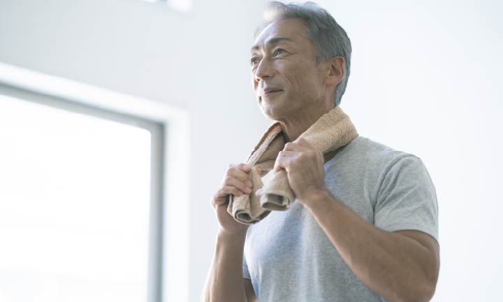 タオルで汗を拭う男性