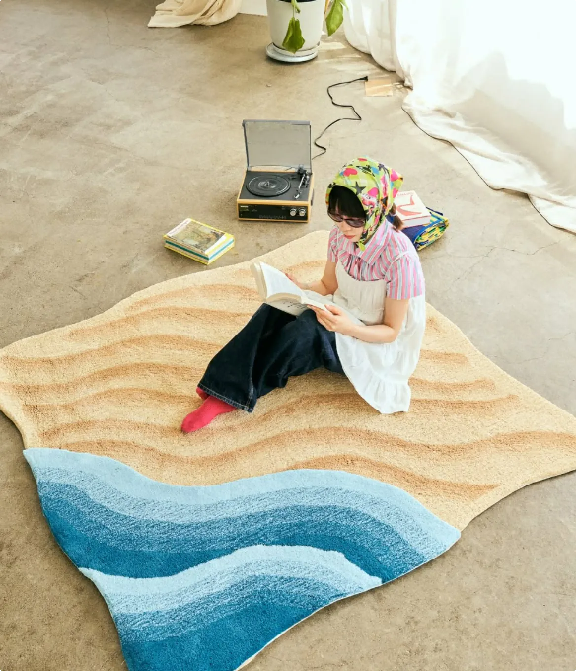 部屋でラグを敷いてくつろぐ人